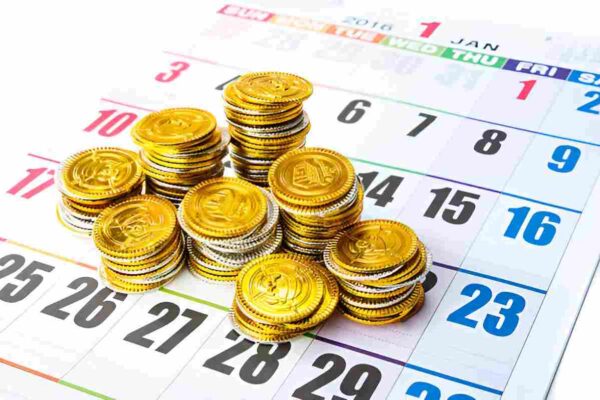 Stacks of gold coins on a calendar, representing Money20/20 event schedule and location